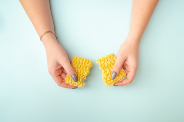 female hands hold two halves of broken paste. Girl smashed pasta