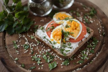 bread with tomato and cheese.
sliced bread with eggs, tomatoes and sour cream. Diet sandwich breakfast.