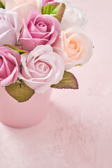 Festive composition with beautiful delicate roses flowers in pink round box on light pink background. Flat lay, copy space. Greeting card.
