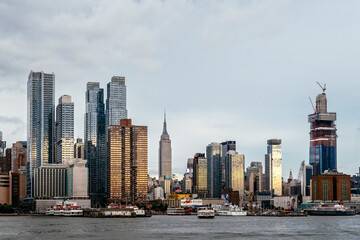 Modern buildings in city by river against sky