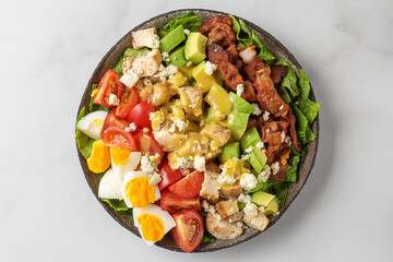 Healthy cobb salad with chicken, avocado, bacon, blue cheese, tomato and eggs. Keto diet food. Top view