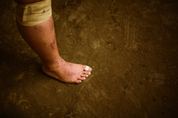 Low section of wrestler standing on sand in sumo beya