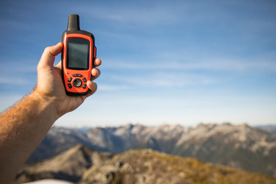 Hiker holding GPS device, Douglas Peak, British Columbia.