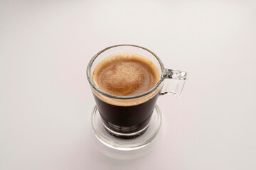 Black coffee in a glass cup and saucer 