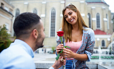 Young man surprised his girlfriend with a red rose. Love and relationships