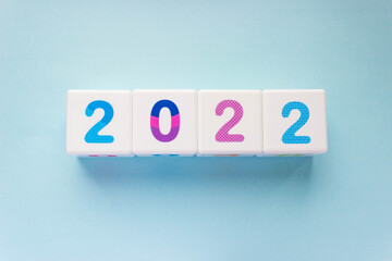 Cubes with colorful numbers 2022 on blue background. New year, calendar. Figures in a row