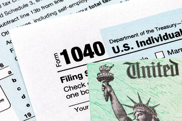 1040 individual income tax return form and tax refund check. Concept of filing taxes, taxable income and tax information. - obrazy, fototapety, plakaty