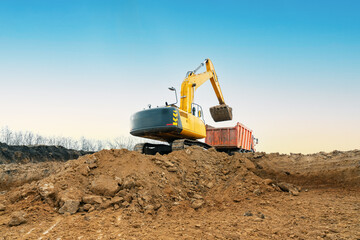 A large construction excavator of yellow color on the construction site in a quarry for quarrying....