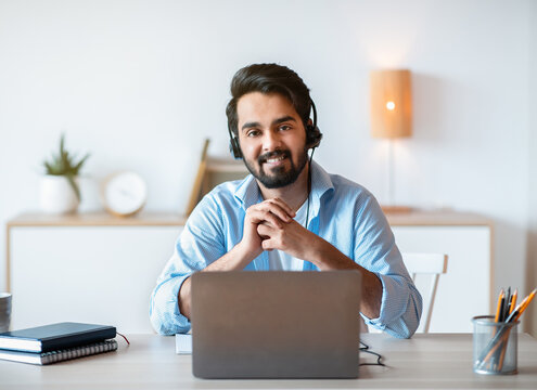 Remote Job. Smiling Arab Man Hotline Manager In Headset Posing At Workplace