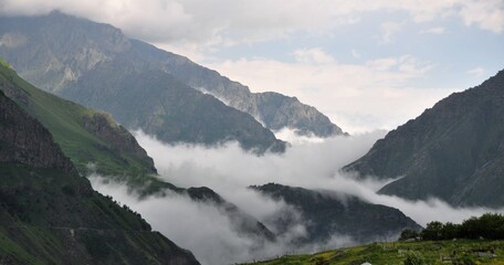 Obraz premium Clouds covering a mountain valley