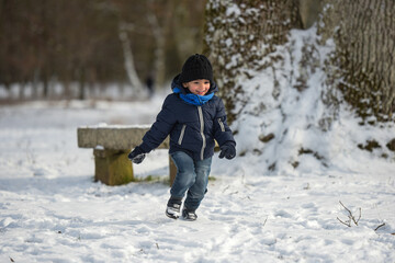 young child playing with the snow
