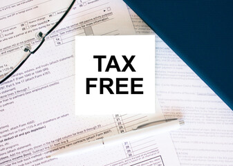 Tax form with business card with text Tax Free. Notepad, eyeglasses and white pen