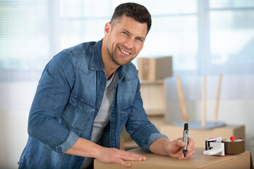portrait of casual delivery writing on a box