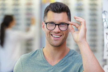 man trying on new glasses at opticians