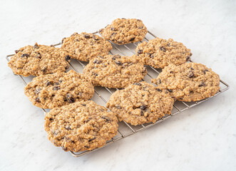 Tasty homemade raisin oatmeal cookies on a white marble countertop.