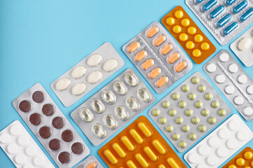 Top view of blisters pack of medicine pills on a blue background. Heap of pills - medical background