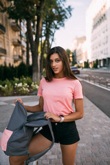 Young woman with open backpack on the street