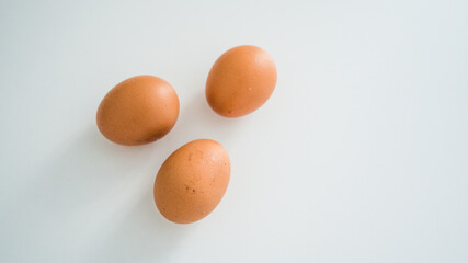 Close up of fresh raw brown chicken eggs on white table. Ingridients for healthy food. Top view.