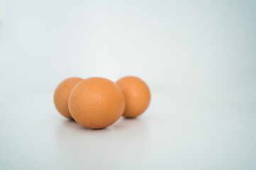 Close up of fresh raw brown chicken eggs on white table. Ingridients for healthy food. Top view.