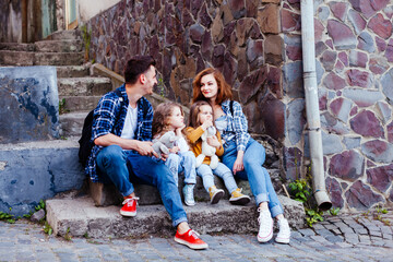 the young family are resting while walking the old city