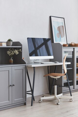 Vertical background image of minimal home workplace with wooden chair in grey and white tone interior, copy space