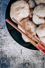 Hericium erinaceus or Lions mane mushrooms on a plate with Chinese sticks © stivog