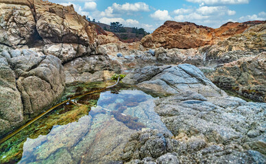 Beautiful seascape, ocean views, rocky coast, sunlight on the horizon. Composition of nature. Sunset scenery background. Cloudy sky. Water Reflection. California Seashore.