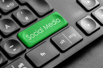 grüne "Social Media" Taste auf einer dunklen Tastatur	