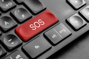 rote "SOS" Taste auf einer dunklen Tastatur