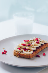 Healthy breakfast toast with chocolate peanut butter, banana, pumpkin, sunflower and flax seeds, sesame, goji berries. Copy space