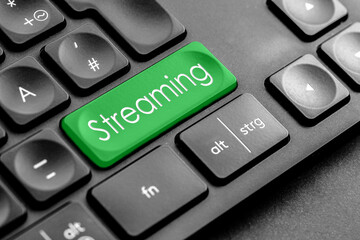 grüne "Streaming" Taste auf einer dunklen Tastatur	