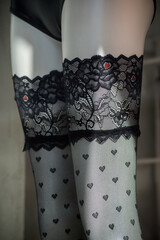 Closeup of black lace stockings on legs of mannequin in a fashion store showroom