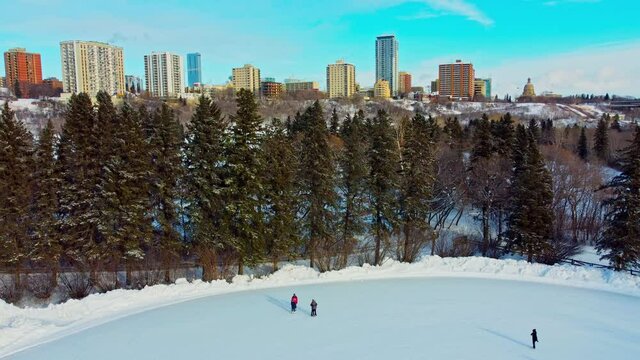 Winter in Victoria Park Skating Rink double date during -35 Celsius afternoon with a background horizon overlooking the valley ice park the Hendrix, the Legislature, Crestview Tower Condominium EDM3-4
