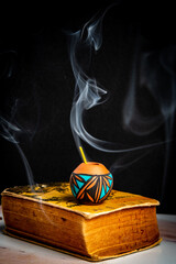 A Mini Hand Made Pottery Vase on top of an Old Book Found at an Estate sale.