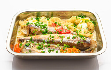 hake fish baked with vegetables close view, baking tray with tomatoes, broccoli and spices, home cooking