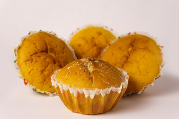 Four cupcakes on a plate on a white background