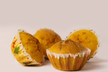 Four cupcakes on a plate on a white background