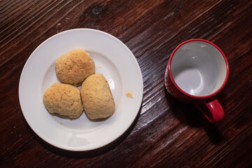 a plate with three bread rolls and a red cup