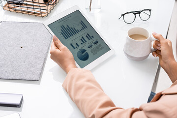 Hands of young businesswoman or banker with tablet analyzing financial data