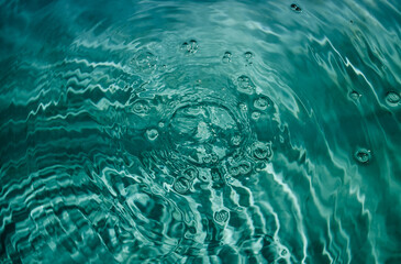Swimming pool water background with drops and bubbles in tidewater green color.