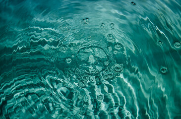 Swimming pool water background with drops and bubbles in tidewater green color.