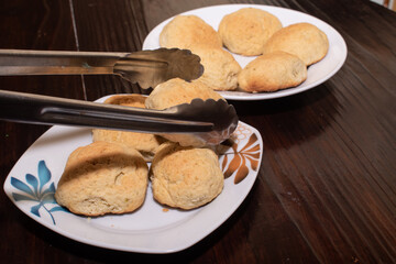 two white plates with homemade bread rolls and tongs