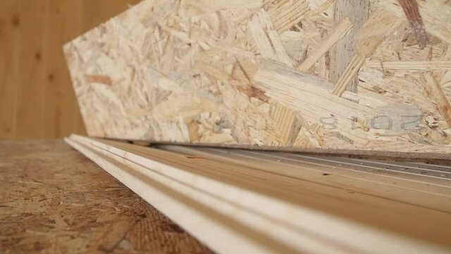 Travelling of some OSB in detail of a carpentry work in a new building site all made of wood