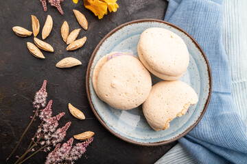 Meringues cakes with cup of coffee on a black concrete background. Top view, close up.