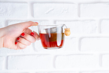 White woman hands with red nails, Cup of Tea, on white background with chocolate Tablet, croissant, chocolate puff pastry, sugar puff pastry, whole grain panela