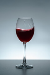 Glass with red wine on black background