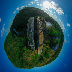 Spherical, Little Planet-Style Panorama of an Old and New Bridge extending over a River in the Countryside, on a Bright Sunny Day with Blue Skies