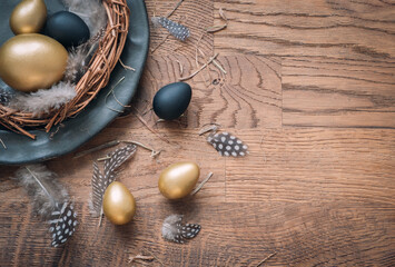Easter festive background. Top view of easter eggs colored with golden paint on dark wood background. Flat lay trendy easter. Happy easter card. Copy space for text