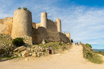 Fototapeta na wymiar familia de mujer y dos niños cogidos de la mano, paseando delante de las ruinas del castillo de Alcalá de xivert, provincia de Castellón de la plana , España , 