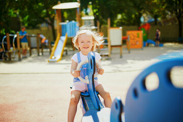 Fototapeta na wymiar Adorable little girl having fun on seesaw